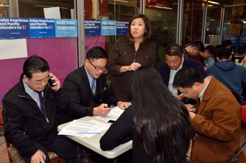 孟昭文(立者)连同民选官员与志工在法拉盛发动电话拜票,为希拉里拉选票。(记者朱泽人/摄影)