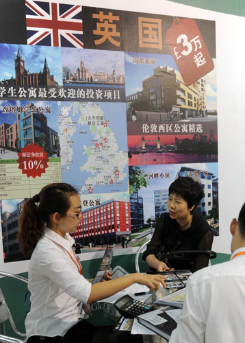 资料图:几名投资者在了解来自英国的一个房产项目的情况。新华社记者罗晓光摄