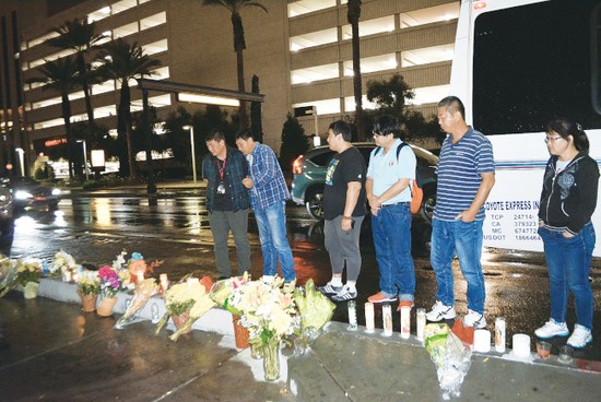 日前，美国华人导游季富力拉斯维加斯遇害，同业和路人摆满鲜花，燃点蜡烛纪念季富力。（美国《世界日报》/冯鸣台