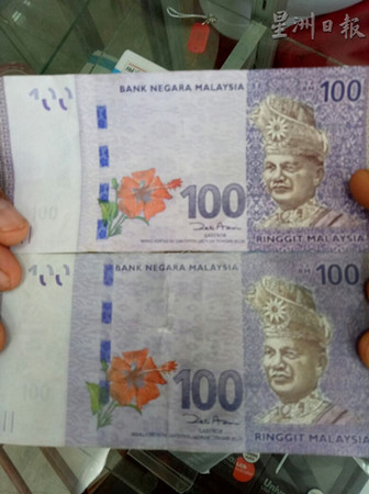 真钞（上）与伪钞（下）的差异在于真钞色质较亮，伪钞的元首肖像则缺乏水印。（马来西亚《星洲日报》）