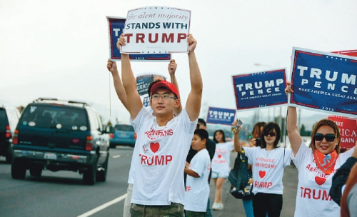 华裔特朗普助选团的成员在路边高举标语支持特朗普。（美国《侨报》/资料图）