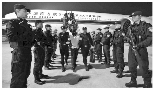 中国侨网图为警方押解嫌疑人下飞机。张伟　摄