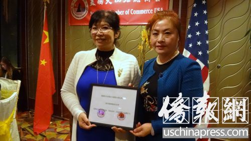 中国侨网大西北总商会会长江风年(左)和东北总商会会长路霞(右)在姐妹商会的揭牌仪式中合影。(美国《侨报》/高睿 摄)