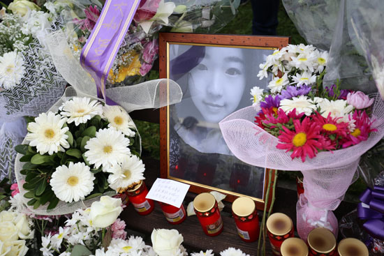 中国侨网11日，罗马，鲜花与蜡烛围绕着张瑶的遗照。（法国《欧洲时报》/张锐 方曼青 摄）