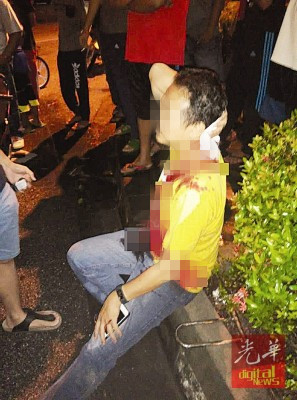 中国侨网商人头部被攻击,血流满脸,衣服一片鲜血等待救援。(马来西亚《光华日报》)