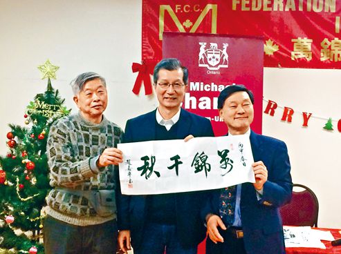 中国侨网万锦加华联会主席吴建忠医生(右)和该中心长者代表向陈国治(中)赠送书法作品。(加拿大《星岛日报》)