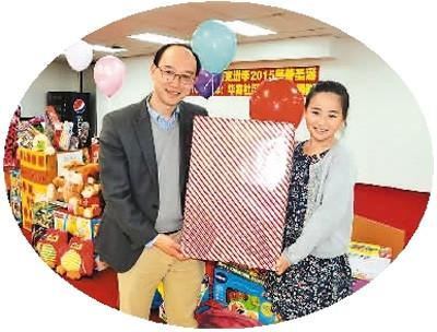 中国侨网圣诞节前，一对参加玩具大派送的父女在美国休斯敦展示他们捐赠的礼品。 　　新华社记者 张永兴摄 
