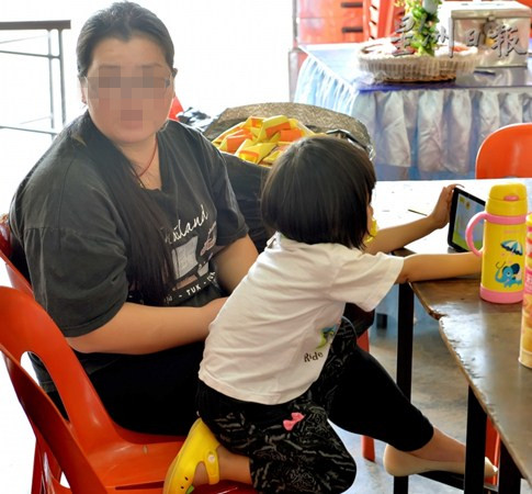 中国侨网李葭(左)表示接下来打算把孩子带回中国生活,一旁年幼的长女因不晓得父亲已离世,并称爸爸只是睡着了,令人听了心酸。(马来西亚《星洲日报》)
