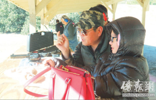 中国侨网华人教练教枪友如何正确使用手枪。(美国《侨报》/高睿 摄)