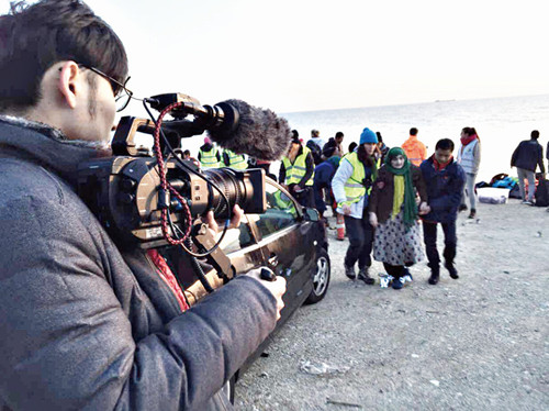 中国侨网华人志愿者在难民登陆现场进行拍摄记录工作。（《欧洲时报》意大利版）