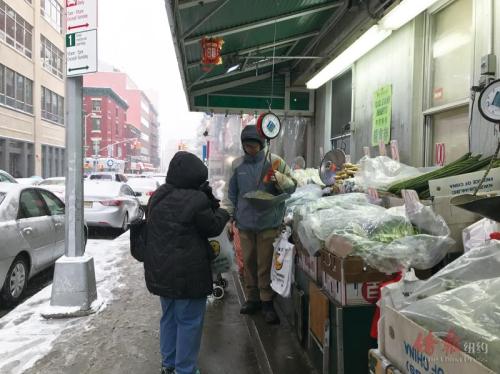 中国侨网民众在摊位上购买蔬菜。（美国《侨报》/陈辰 摄） 