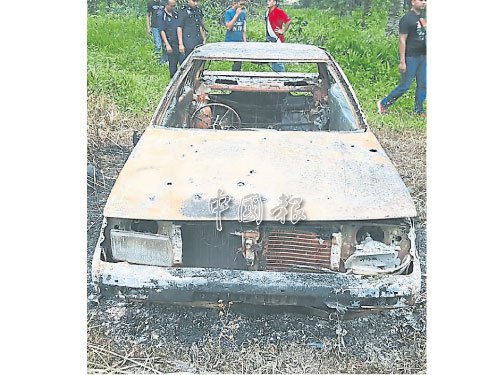 中国侨网民众在油棕园内发现被烧毁的车子及死者遗体。(马来西亚《中国报》)