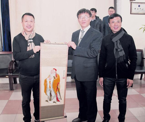 中国侨网张宏明(前排左2)向法国华侨华人会赠送孔子绣像。(法国《欧洲时报》/黄冠杰 摄)