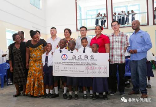 中国侨网商会成员与老师、学生合影。(非洲《华侨周报》)
