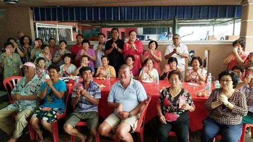 中国侨网阿兹米(后左九)等人与邻居们一起向大家拜早年。(马来西亚《星洲日报》)