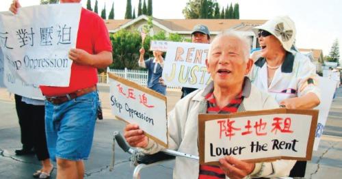 中国侨网活动房园区华裔居民举着“反压迫”、“降地租”的标语在园区内示威游行。（美国《侨报》/居民提供）