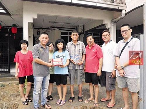 中国侨网林振福（左2）由马青与志工团代表陪同，移交食品及饮料予灾民，并慰问灾民。（马来西亚《光华日报》）