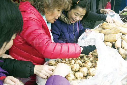 中国侨网家庭主妇开心采购茨菇。（美国《世界日报》／关文杰摄影）