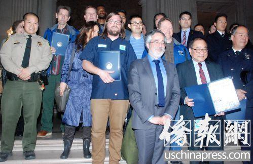 中国侨网市议员佩斯金和受表彰的救火英雄合影。(美国《侨报》/吴卓明 摄)
