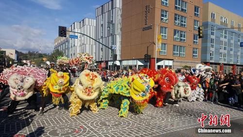 中国侨网丁酉鸡年正月初八,第118届金龙大游行在美国洛杉矶中国城盛大登场。图为游行队伍中精彩的龙狮共舞。中新社记者 张朔 摄