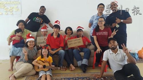中国侨网玛姬达（坐者右一）和部分的自闭儿员工及家长一同欢庆圣诞节。（受访者提供）