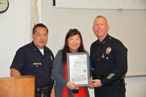 中国侨网西部分局指挥官周宝来(左)、洛市警局副局长Jon F. Peters(右)向Cindy冯(中)颁发奖状。(美国《世界日报》/高梓原 摄)