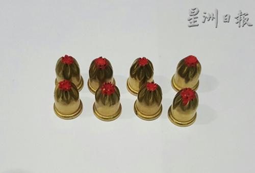 中国侨网警方从嫌犯处起获8枚形似子弹的螺帽。(马来西亚《星洲日报》)