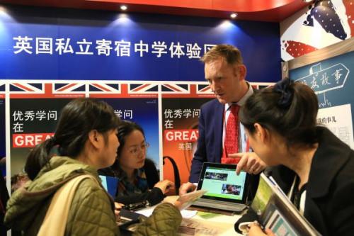 中国侨网工作人员在2013中国国际教育展上，为中国学生介绍英国私立寄宿中学的招生情况。新华社发