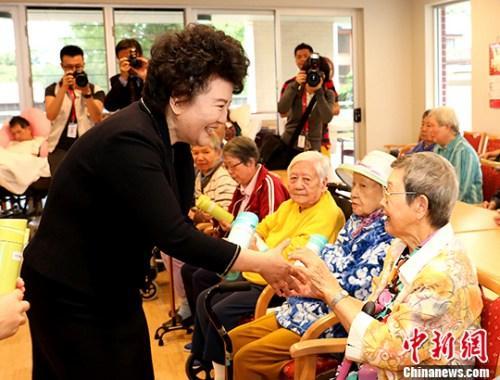 中国侨网图为裘援平向在华助中心生活的老人们赠送礼品。 中新社记者 赖海隆 摄