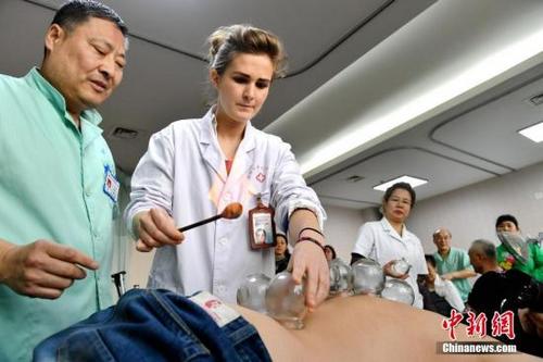中国侨网资料图：法国金发女孩中国研修中医，正在给患者拔罐。 中新社记者 王舒 摄 