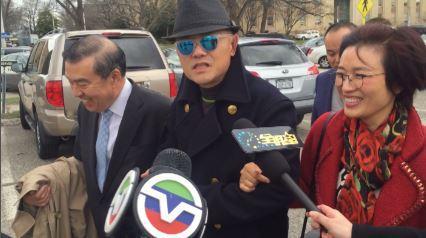 中国侨网资料图:周立波在其太太胡洁与律师莫虎的陪同下现身法庭。(美国中文网)