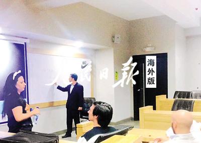 中国侨网组织行为学课开始前，老师正在黑板上写板书，同学们在自由交谈。