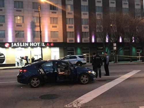 中国侨网一辆深蓝色优步车,在华埠闹区被歹徒拦下并当街开枪。(美国《世界日报》/黄惠玲 摄)