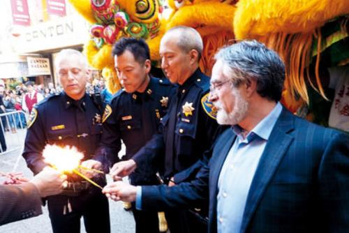 中国侨网三警察荣升左起：拉萨、业培恩、余国良，与代表第三区市议员佩斯金燃点鞭炮。（美国《世界日报》／关文杰 摄）
