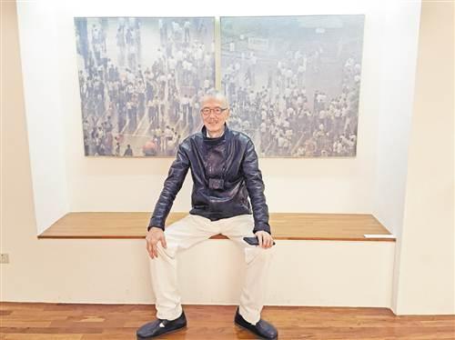 中国侨网“时空回顾”画展现场，韩湘宁在作品《重庆街人》前留影。