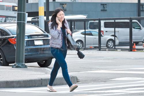 中国侨网边走路边讲手机的亚裔妇女，最容易成为街头劫案的受害人。（美国《世界日报》/李秀兰 摄）