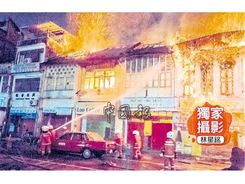 中国侨网华人巴刹一排老店屋凌晨失火，火光猛烈，消防员投入救灾之中。（马来西亚《中国报》）