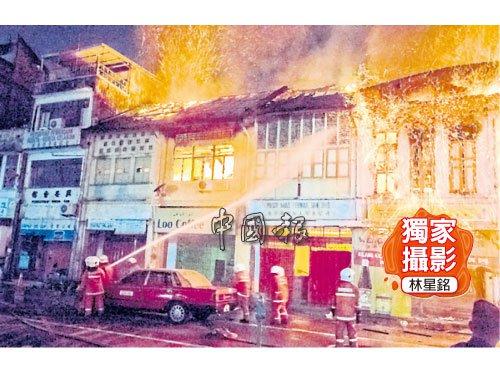 中国侨网华人巴刹一排老店屋凌晨失火,火光猛烈,消防员投入救灾之中。(马来西亚《中国报》)