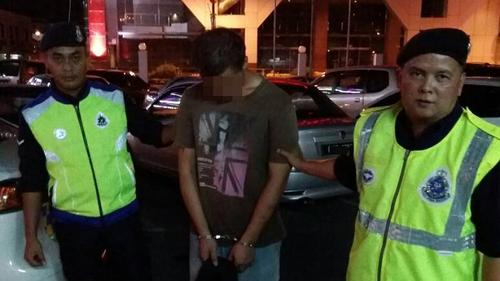 中国侨网被巡警当场逮捕的华裔嫌犯。(马来西亚《诗华日报》)