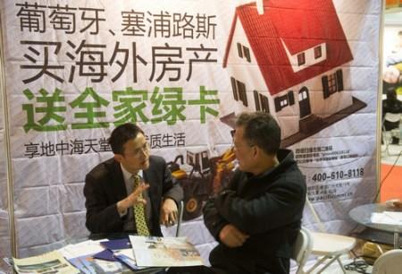 中国侨网一家公司工作人员向前来咨询的人介绍海外购房的详细情况。新华社记者 罗晓光 摄
