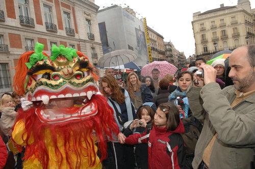 中国侨网资料图片：2009年1月25日，在西班牙首都马德里，华人华侨的舞狮表演吸引众多西班牙人的关注。新华社记者 陈海通 摄