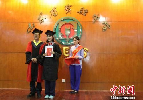 中国侨网山东省实验中学副校长林宝磊为中美高中课程班毕业生颁发毕业证书和精美纪念册。　赵晓　摄