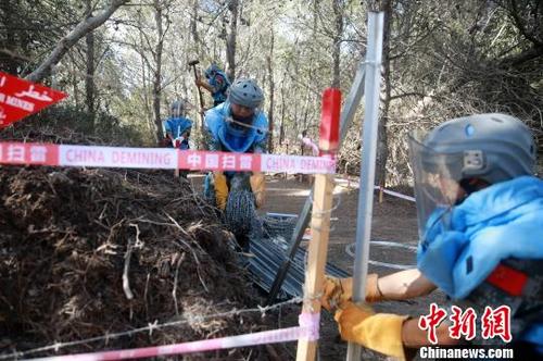 中国侨网对雷场中新开辟的安全通道进行封围作业。　华迅　摄