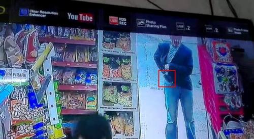 中国侨网图为当时该名歹徒在谢先生店门口准备掏枪进行威胁。(西班牙欧浪网/华人店主提供)
