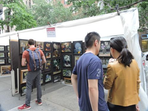 中国侨网华裔情侣在展销会上相中画作,商量要否购买回家。(美国《世界日报》/王靖雯 摄)