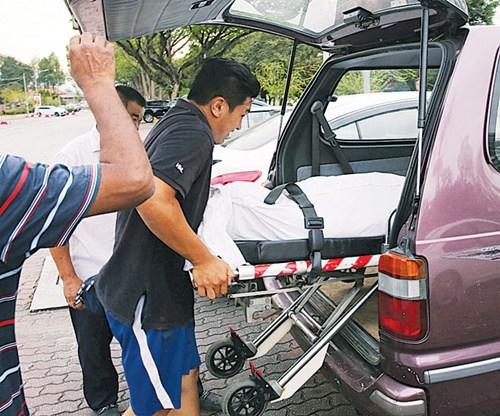 中国侨网死者的遗体被抬上车准备送往医院太平间。（马来西亚《光华日报》）
