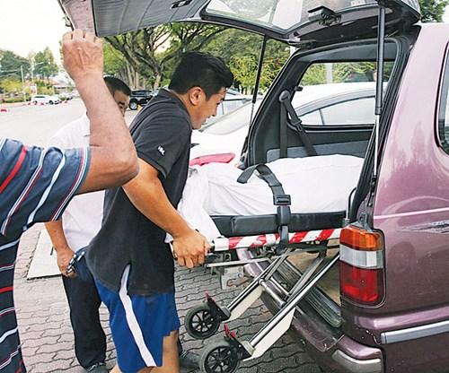 中国侨网死者的遗体被抬上车准备送往医院太平间。(马来西亚《光华日报》)