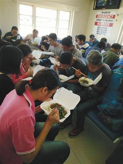 中国侨网获释后的中国同胞在机场吃盒饭。刘造林 摄