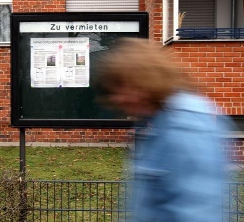 中国侨网资料图片：在德国首都柏林，一名女子走过租房广告栏。新华社记者罗欢欢摄 
