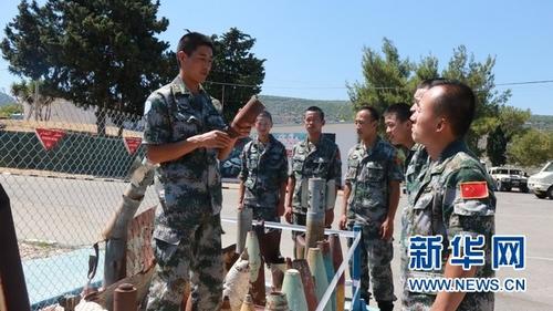 中国侨网扫雷二组组长挪贵东给本组人员讲解排除各类爆炸物时的注意事项。新华网发(牛彦澧摄)